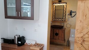 Une cuisine compacte avec des meubles en bois, un four encastré et une machine à café.