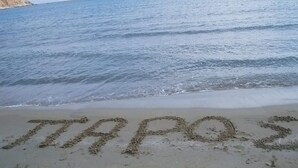 Une plage où le mot « TRAPOS » est écrit dans le sable.