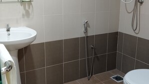A bathroom with a white sink, a toilet, and a shower area. - De Royal Hotel (Ampang)