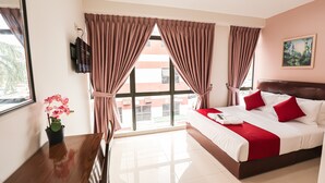 A hotel room with a large bed, a TV mounted on the wall, and a window with curtains. - De Royal Hotel (Ampang)