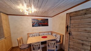 A cozy dining area with a wooden table, chairs, and a bench with floral cushions. - Apartment at the ski slope, Bad Kleinkirchheim (Bad Kleinkirchheim)