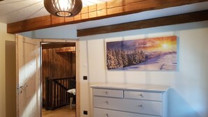 A bedroom with a wooden ceiling, a white dresser, and a painting of a snowy landscape. - Apartment at the ski slope, Bad Kleinkirchheim (Bad Kleinkirchheim)