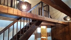 A wooden staircase with metal railings and a hanging light fixture. - Apartment at the ski slope, Bad Kleinkirchheim (Bad Kleinkirchheim)