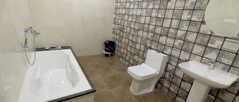 A bathroom with a bathtub, toilet, and sink.