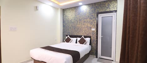 Ein Schlafzimmer mit Bett, einer Tür und einem Deckenventilator.