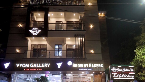 Een meerhoog gebouw met een winkel op de begane grond waar Vyom Gallery en Browny Bakers gevestigd zijn.