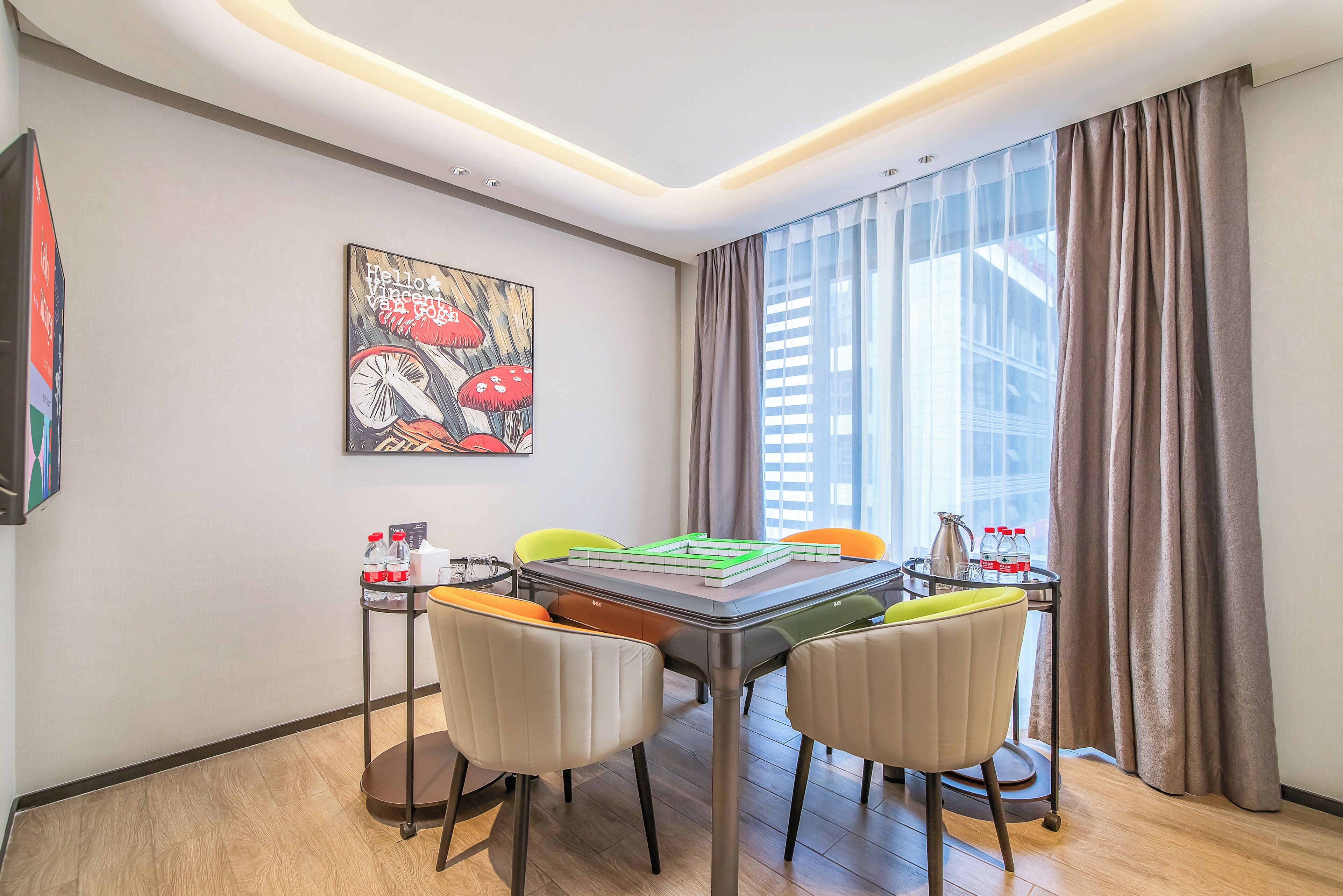 Un espace repas moderne avec une table, des chaises et un tableau accroché au mur.