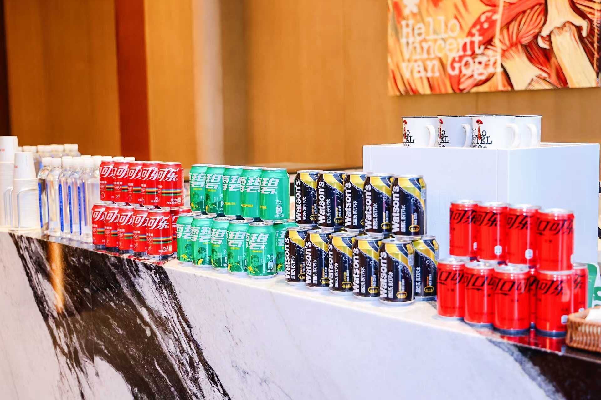 A display of various beverage cans in multiple colors arranged on a counter.