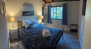 A bedroom with a bed, two bedside lamps, a window with curtains, a painting on the wall, and a radiator. - Welcome To "Snowed Inn” - Walk On And Off The Slopes (McGaheysville)