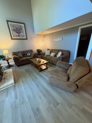 A living room with two sofas, a coffee table, and a lamp. - Welcome To "Snowed Inn” - Walk On And Off The Slopes (McGaheysville)