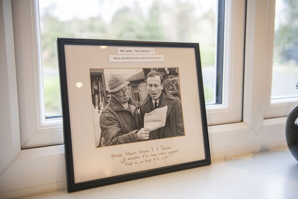 A framed photograph of two men in a vintage setting, with text describing its origin and significance.
