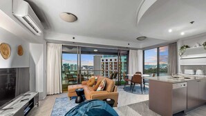 A modern living room with a sofa, coffee table, and a view of the city.