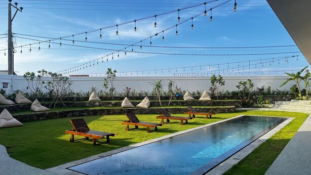 A pool area with lounge chairs and string lights. - Marshmallow Bay (Ahangama)