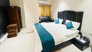 A hotel room with a bed, bedside table, and a wardrobe. - Hotel Royal SKY (Morbi)