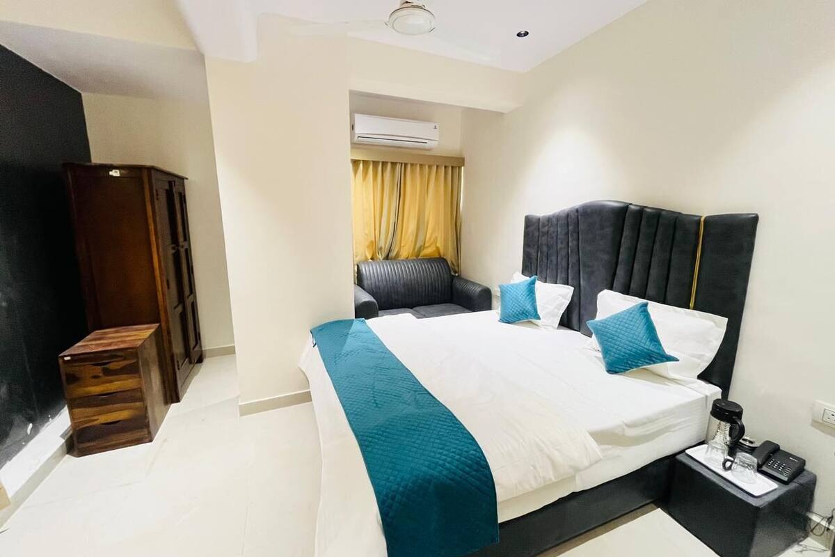 A hotel room with a bed, bedside table, and a wardrobe.