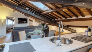 A modern kitchen with a large island, a built-in sink, and a dining area with a table and chairs. - Elegant historic apartment, Dimora Capo di Ferro (Roma)