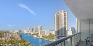 A high-rise building with a view of a river and other buildings.
