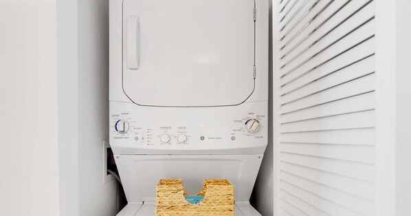 A front view of a white washing machine with control knobs, a detergent dispenser, and a lint filter. - Modern 1BR with Pool & Balcony (Hallandale Beach)