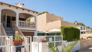 A residential building with a white facade, a balcony, and a gated entrance. - De Vacances by Interhome (Son Serra Marina)