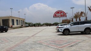 A parking lot with a building labeled "Golden Cresida Resort & Palace" and a signboard. - GOLDEN CRESSIDA RESORT & PALACE (Mozamabad)
