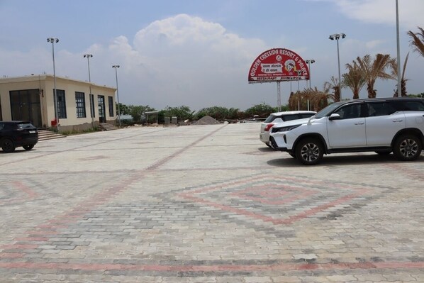 A parking lot with a building labeled "Golden Cresida Resort & Palace" and a signboard.