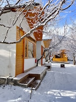 Um edifício coberto de neve com fachada de madeira e janelas grandes.