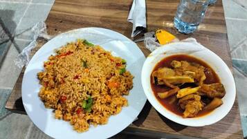 Un plato de arroz frito con vegetales y un tazón de estofado de pollo.
