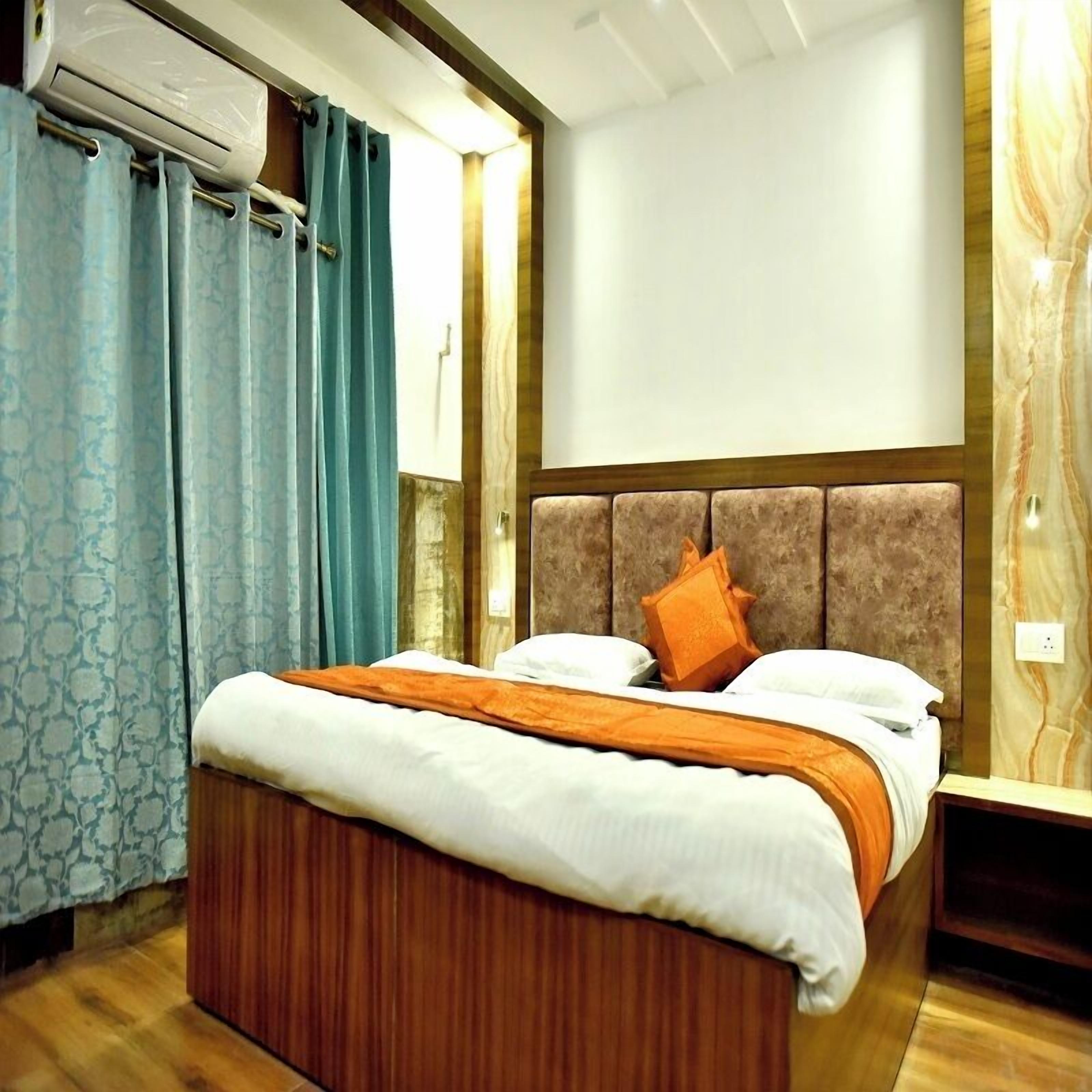 A bedroom with a wooden bed, a headboard, a nightstand, and a wall-mounted air conditioning unit.
