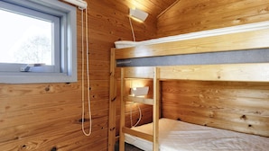 A wooden cabin room with bunk beds, a window, and a small shelf. - 5 Star Holiday Home in Lokken (Lokken)