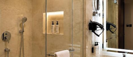 A modern bathroom with a glass-enclosed shower, a sink, and a mirror.
