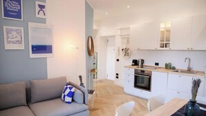 A modern living room with a grey sofa, a dining table with chairs, and a kitchen area with white cabinets and a wooden countertop. - *Bright 2-Room Apartment for friends and relatives*10 MINUTES FROM THE CATHEDRAL (Milano)