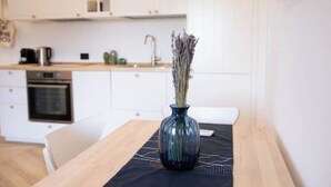 A modern kitchen with white cabinets, a wooden countertop, and a vase with dried flowers on a table. - *Bright 2-Room Apartment for friends and relatives*10 MINUTES FROM THE CATHEDRAL (Milano)