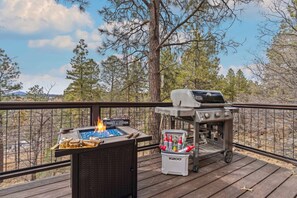 A deck with a grill, a portable cooler, and a fire pit. - Forest View Cabin*Arcade*Xbox*Fully Fenced (Flagstaff)
