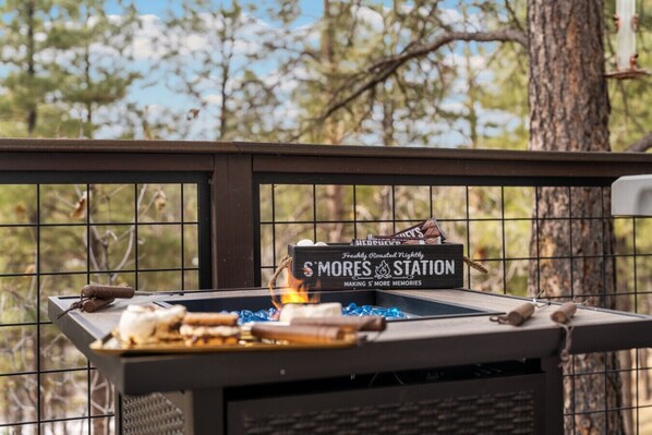 A barbecue grill with a sign reading 'S'Mores Station' and a box of Hershey's chocolate bars. - Forest View Cabin*Arcade*Xbox*Fully Fenced (Flagstaff)