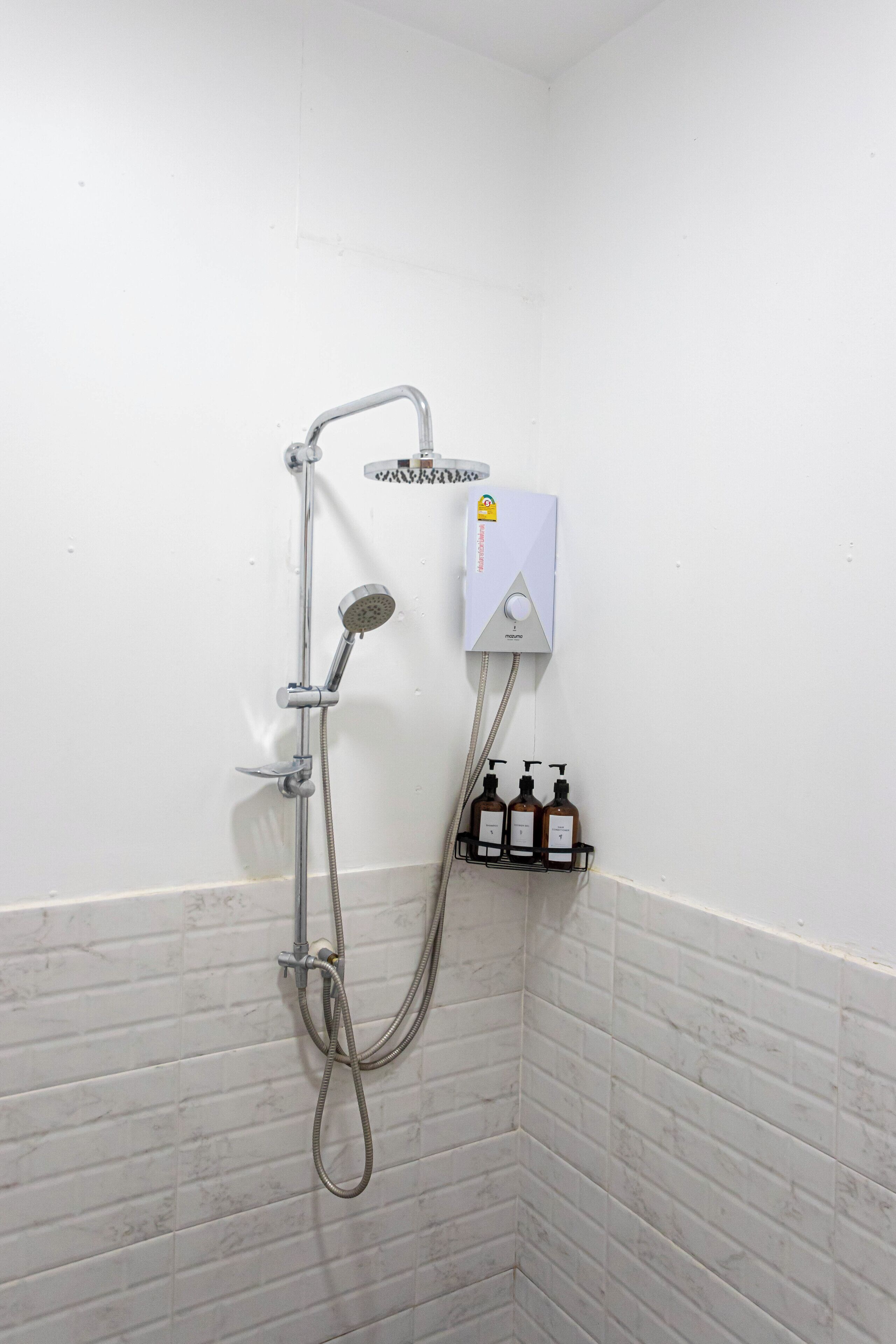 Ducha con cabezal de ducha de mano y panel de control en la pared.