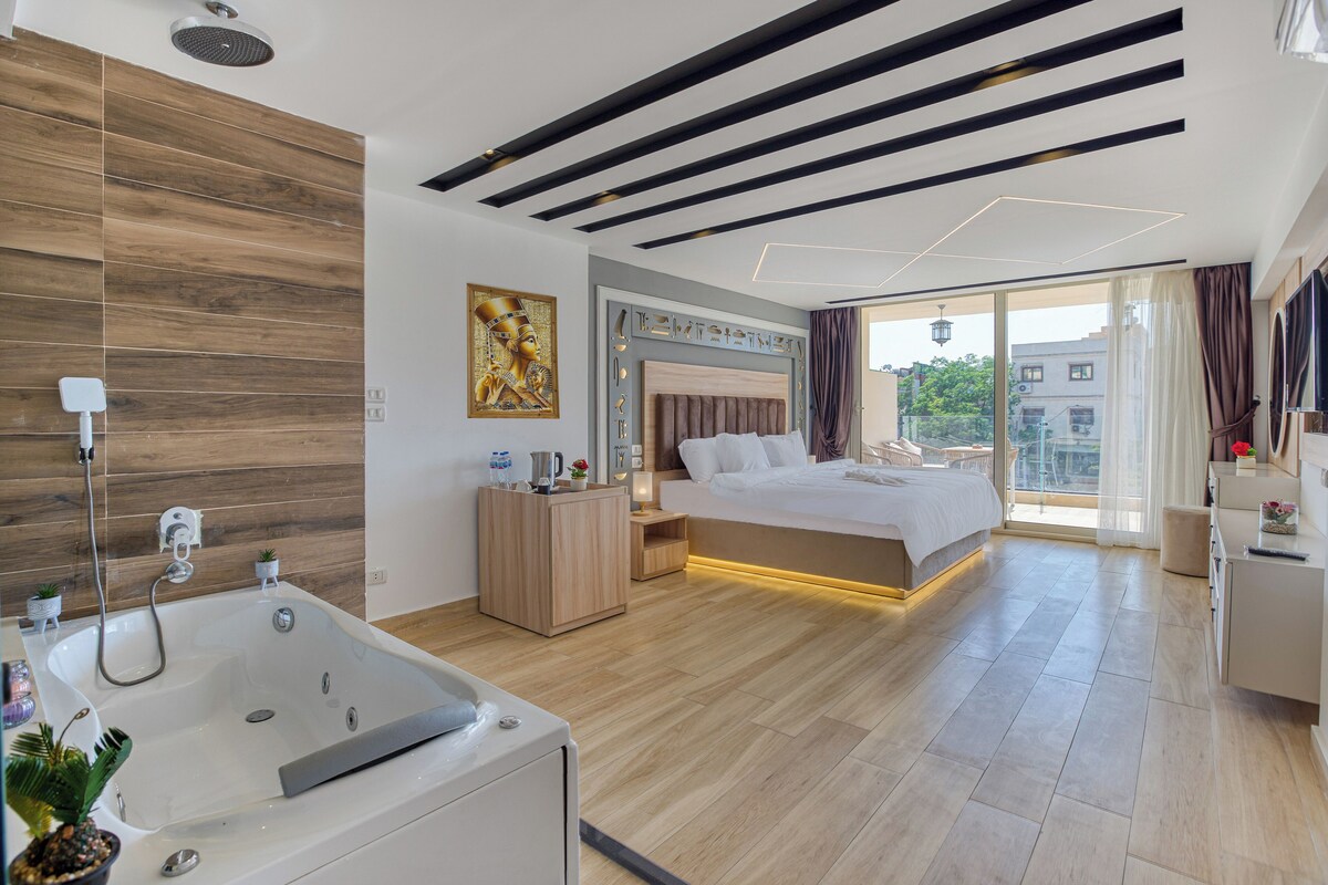 Un dormitorio moderno con una cama grande, una bañera y un balcón con vista a la ciudad.