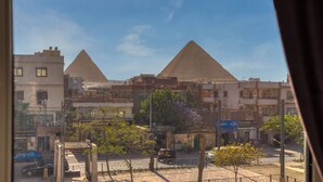 Vista de las pirámides desde una ventana con vistas a una calle con edificios y tiendas.