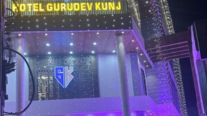 A hotel with a modern design, featuring a prominent logo and illuminated signage. - Hotel Gurudev Kunj (Faizabad)