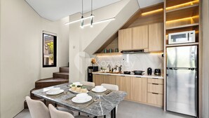 A modern kitchen with a built-in microwave, stainless steel refrigerator, and wooden cabinets. - Marea Villa by Kozystay - Jimbaran (Jimbaran)