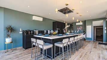 Une cuisine moderne dotée d’un îlot central, de tabourets de bar et d’un coin repas.
