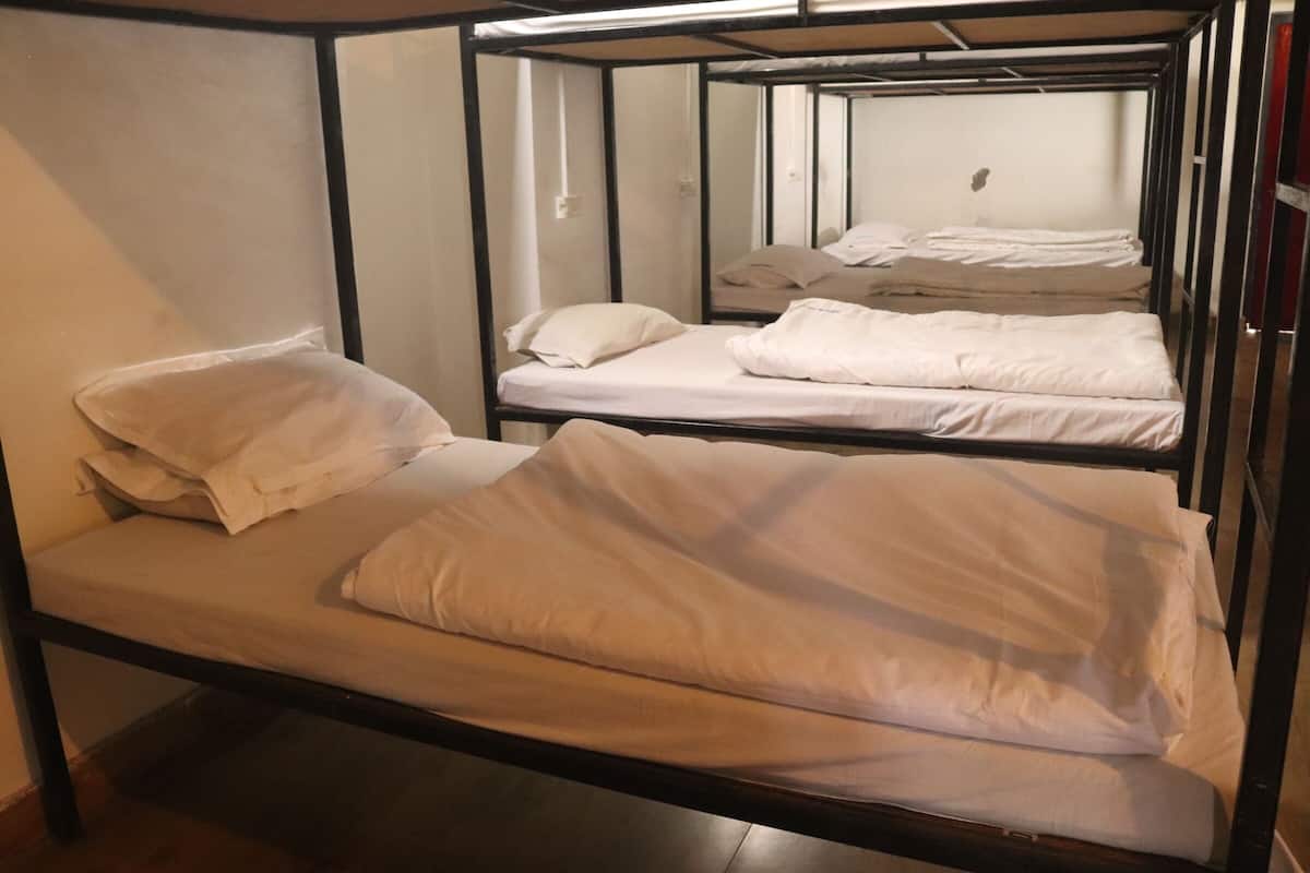 Habitación con literas, dos camas con ropa blanca y almohadas.