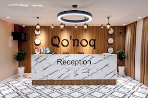 A reception desk with a marble top, wooden paneling, and clocks indicating different cities.