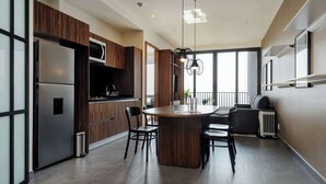 Une cuisine moderne dotée d’un îlot central, d’appareils électroménagers en acier inoxydable et d’un coin repas avec des chaises.