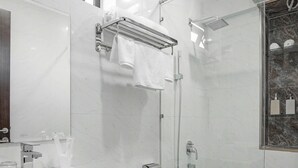 A modern bathroom with a white sink, toilet, and shower. - Dragon View Riverfront Hotel  (Da Nang)