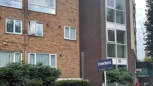 Un edificio de varios pisos con un cartel que dice "Dexters".