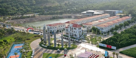 A hotel with multiple buildings, a sports court, and a parking area.