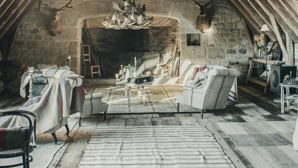 A cozy attic room with a stone fireplace, wooden beams, and a rustic aesthetic. - Le buron de Perrier  (Saint urcize)
