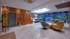 A modern lobby with a reception desk, seating area, and a large aquarium. - Nest By TreeHouse Stamp Amritsar (Amritsar)