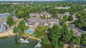 An aerial view of a residential area with a large building complex, a dock, and a swimming pool.