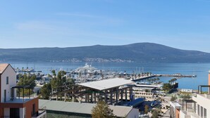 A marina with yachts and boats, a dock, and a mountainous backdrop. - SIRO Porto Montenegro (Tivat)